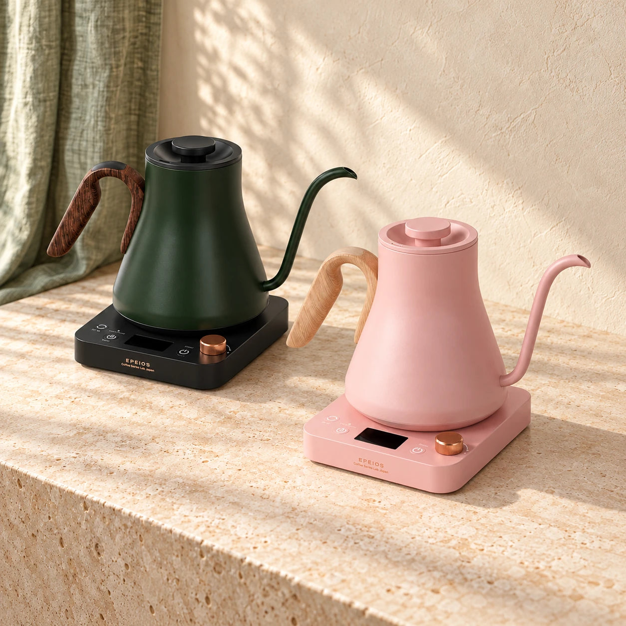 Green and Pink EPEIOS gooseneck kettles on a light stone counter