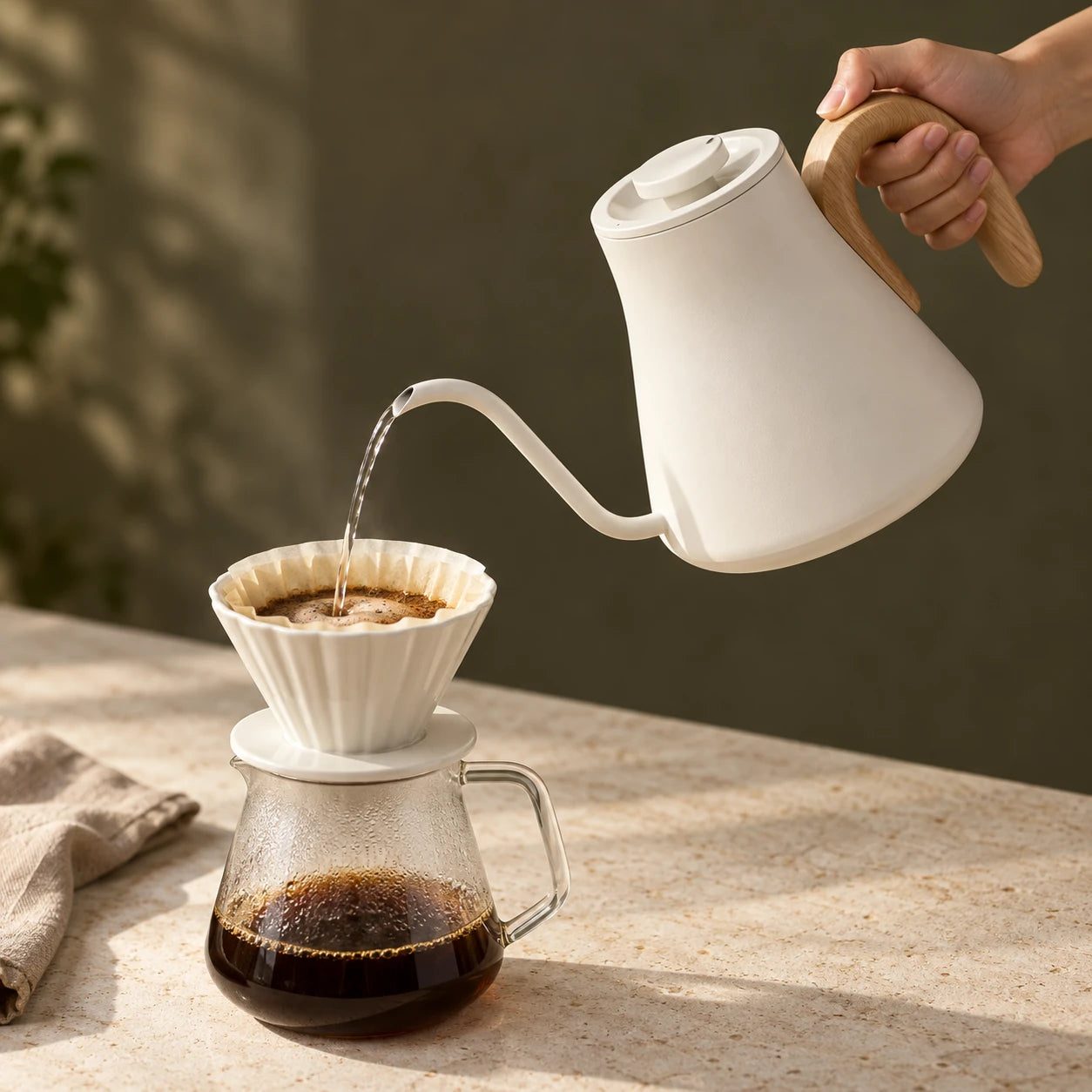 A Cream White Walnut EPEIOS kettle pouring coffee by a sunlit window
