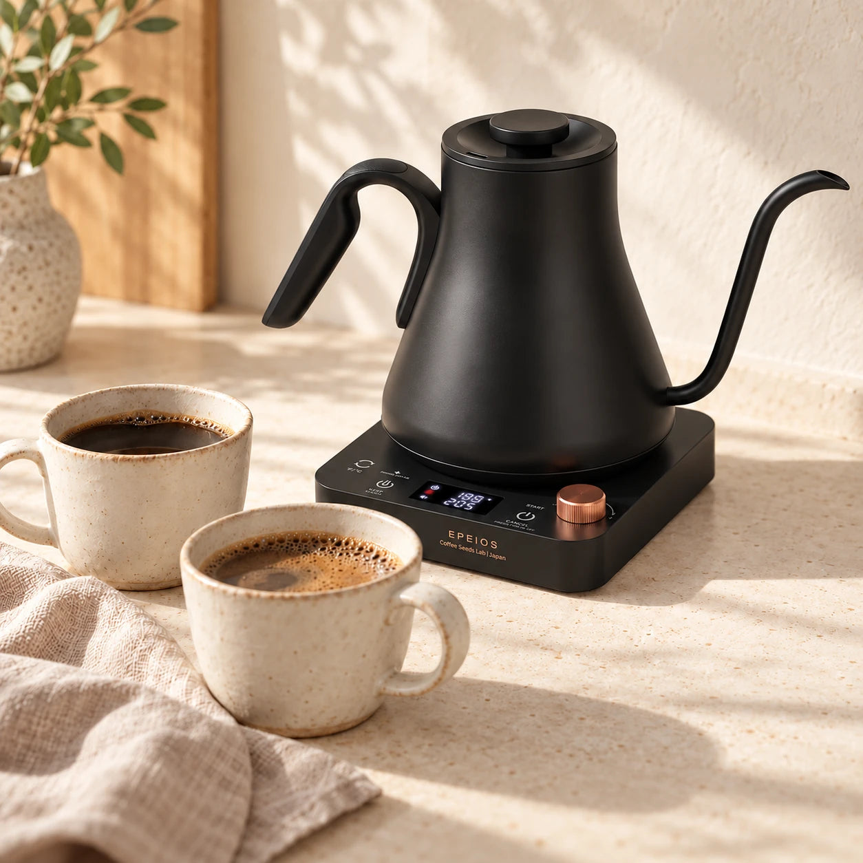 The gooseneck kettle beside two cups of coffee